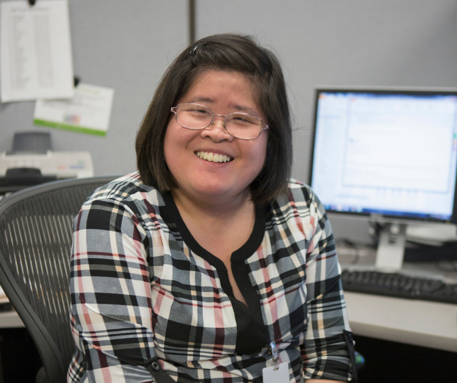 Image of a woman at a computer, smiling.